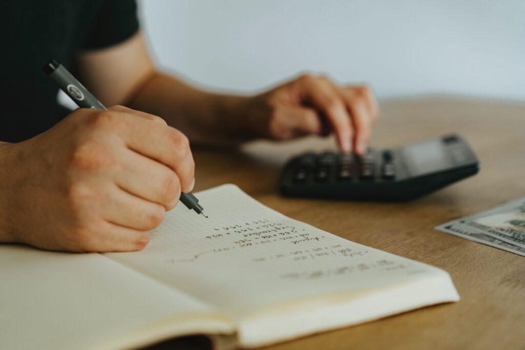 accountant working with calculator and writing in book