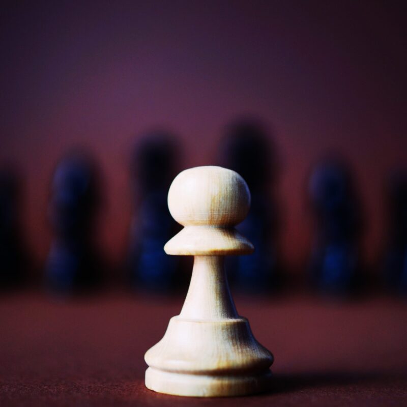 white chess piece in front of other chess pieces